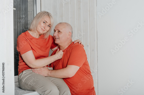 husband and wife in orange t-shirts hug and kiss © Владимир Паляница