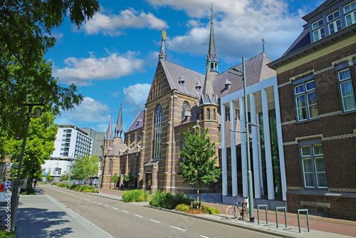 Wallpaper Mural Eindhoven, Netherlands - July 17. 2022: City street with medieval gothic augustine church and marienhage hotel, blue summer sky fluffy clouds Torontodigital.ca