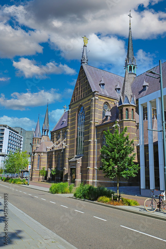 Eindhoven (Augustijnenkerk), Netherlands - July 17. 2022: City street with medieval augustine church, blue summer sky fluffy clouds photo