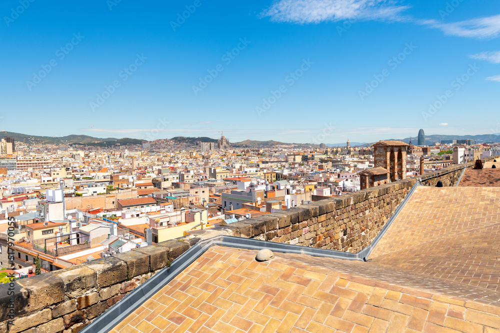 The skyline and mountains of Barcelona Spain including La Sagrada Familia and Torre Glòries seen from the rooftop terrace of the Basilica of Santa Maria del Mar in the Ribera district.