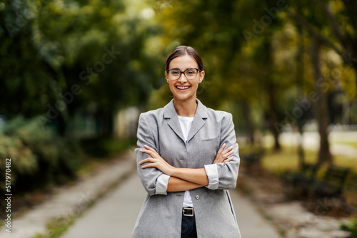 A successful young businesswoman standing in a park with arms crossed. Success will come to you wherever you are. A businesswoman in a park