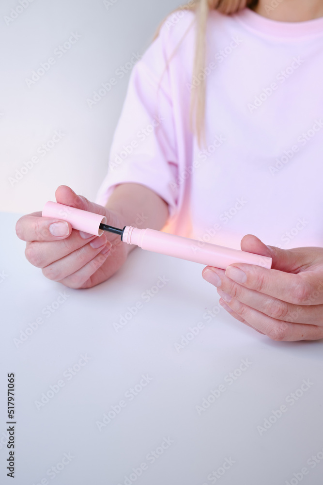 Girl hold mascara. Eyelash brush. Pink tube of mascara. Makeup cosmetics
Girl hold mascara. Eyelash brush. Pink tube of mascara. Makeup cosmetics