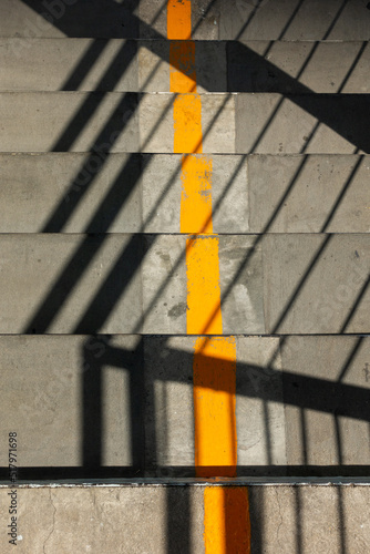 Fotografiet yellow line and direction arrow painted and shadow background on a pedestrian ov