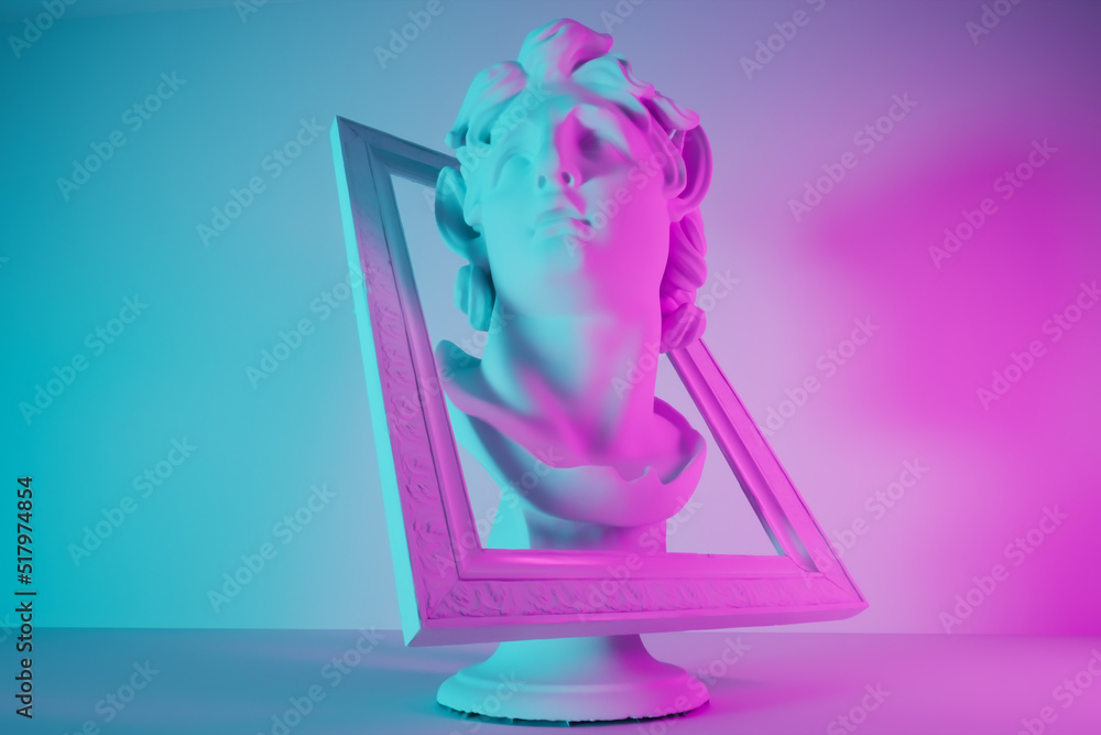 still life with an antique bust of a triton in modern dual lighting in pink and blue, head looks out of a picture frame