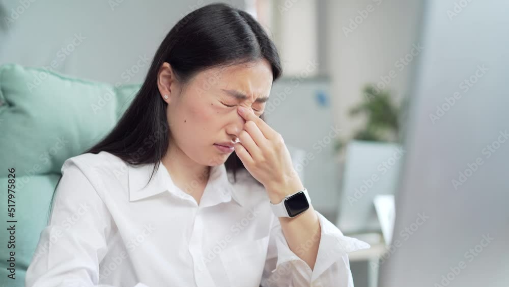Exhausted, overworked asian office worker sitting in the workplace with severe headache massaging his head. unhealthy Tired female employee in pain ache sick Stress sedentary working computer. Asia Exhausted, overworked asian office worker sitting in the workplace with severe headache massaging his head. unhealthy Tired female employee in pain ache sick Stress sedentary working computer. Asia