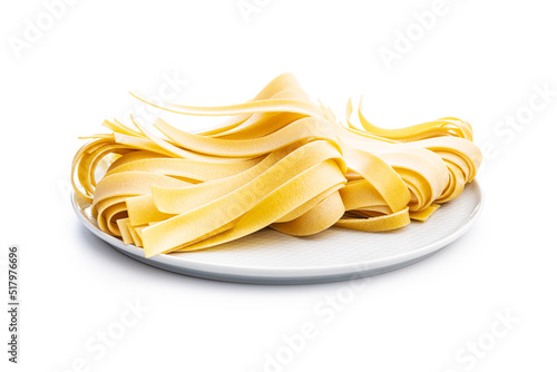 Uncooked pappardelle pasta isolated on white background.