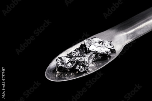 Chromium fragments on trowel, industrial use ore, metallic chemical element, isolated on black background © RHJ
