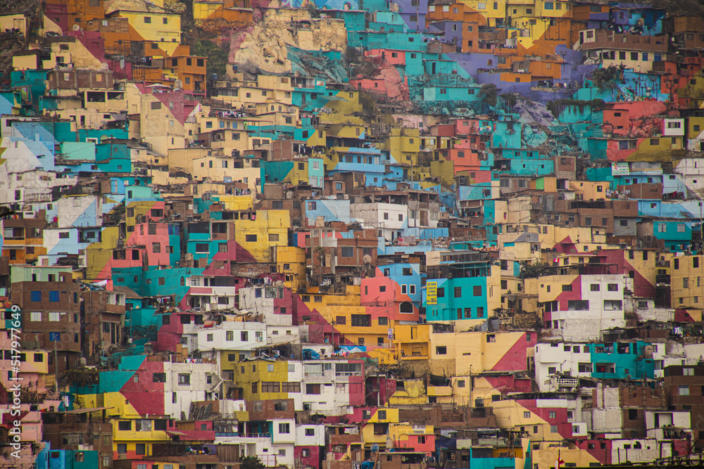 Group of colorful houses. Favelas in the mountains. Areas inhabited by the poor. Lima, Peru - July 16, 2022: Part of shanty town on side of Cerro San Cristobal, Andes Mountain.