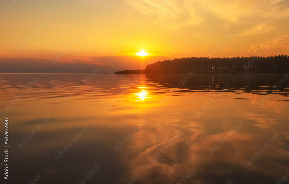 Tranquil golden hour cloud above the forest lake at sunset. Dramatic cloudscape. Symmetry reflections on the water, natural mirror. water ripple sunset background.