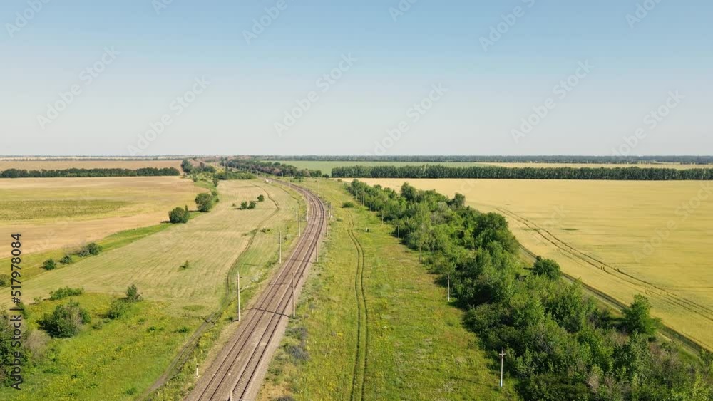 Railway line is carried over gravel and concrete sleepers in rural landscape, aerial view Railway line is carried over gravel and concrete sleepers in rural landscape, aerial view