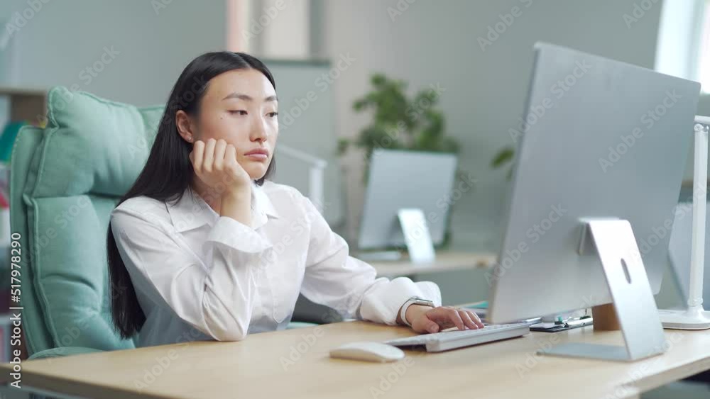 Bored sleepy Asian office worker sitting at work workplace at computer desk leaning on hand. Tired woman. Exhausted young Businesswoman employee. Portrait Depressed, unhappy, workless female manager Bored sleepy Asian office worker sitting at work workplace at computer desk leaning on hand. Tired woman. Exhausted young Businesswoman employee. Portrait Depressed, unhappy, workless female manager