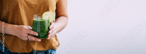 Принти на полотні Female hands hold a glass of freshly made green smoothie, selective focus, copy space