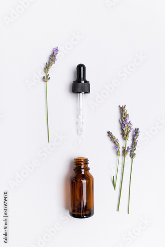 Brown glass bottles with pipette with lavender essence oil  lavender flowers on white background top view. Natural cosmetics with lavender extract  aromatherapy  spa  body care  mock up