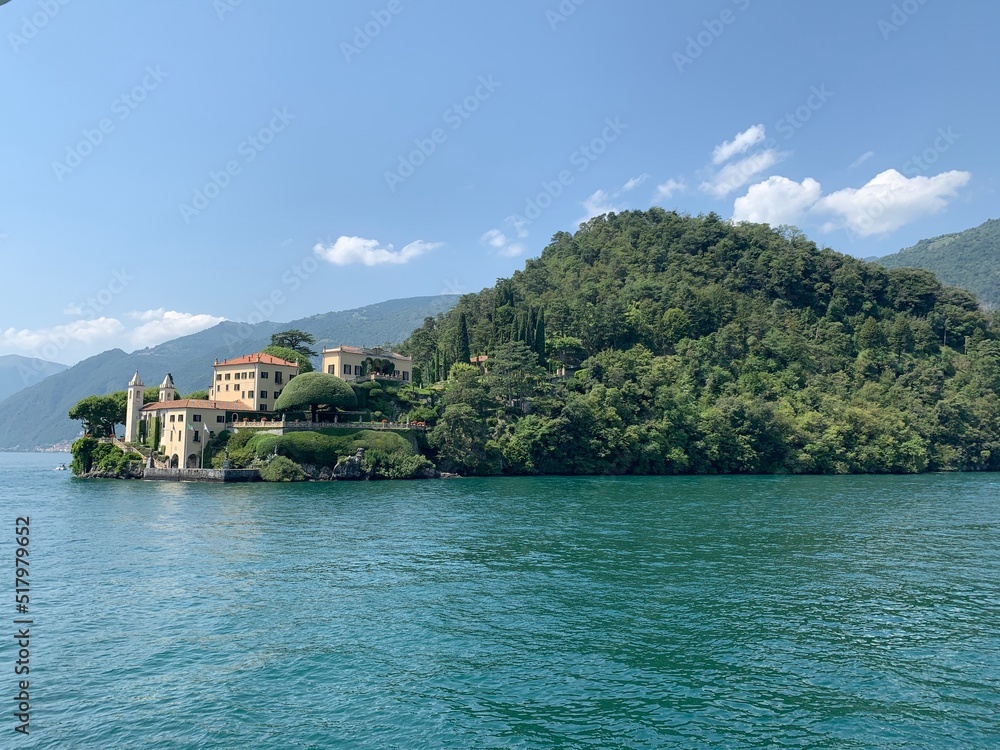 Landscape of Como Lake shore and Villa del Balbianello mansion house surrounded by trees. Emerald blue water.  Tremezzo, Como Lake, Lombardy, Italy