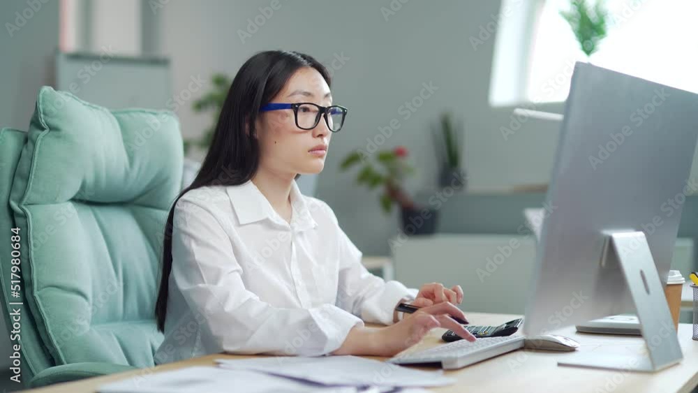 young asian woman accountant clerk working with documents in office at workplace. Busy doing Paperwork calculation financial report. Uses a calculator PC computer laptop. female Employee entrepreneur young asian woman accountant clerk working with documents in office at workplace. Busy doing Paperwork calculation financial report. Uses a calculator PC computer laptop. female Employee entrepreneur