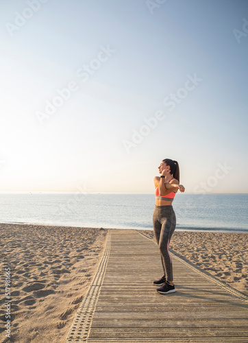 Healthy sport girl doing early morning stretching exercise on the beach. © Paolo Corazza