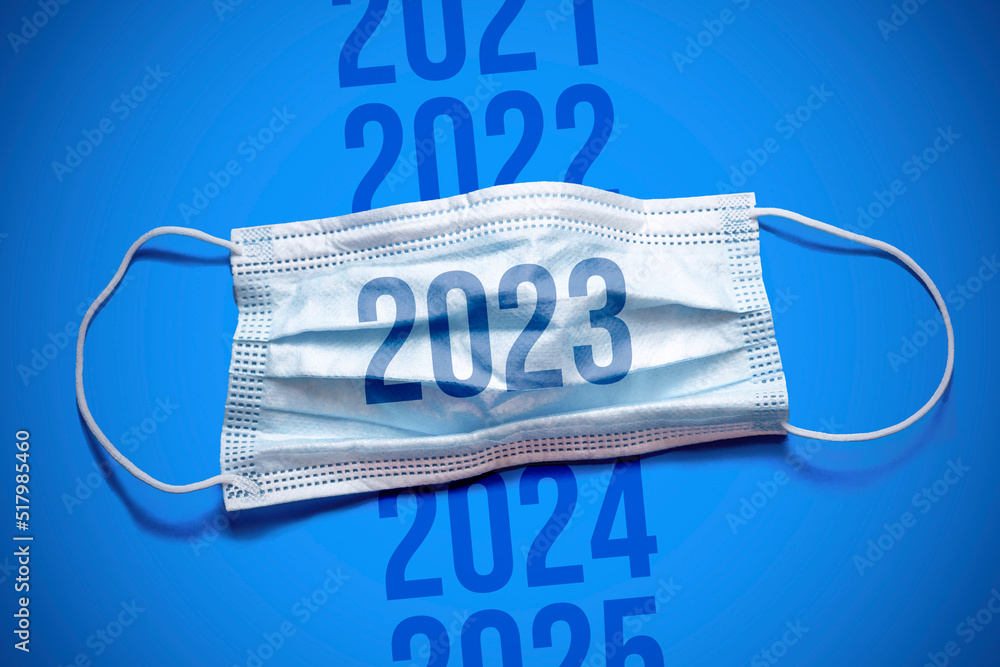 A new jump in the incidence of the Omicron strain. Lettering 2022 2023 2024 and medical mask. The return of the coronavirus