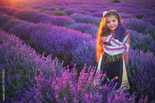 Girl with flowers in traditional folklore bulgarian dress in lavender field