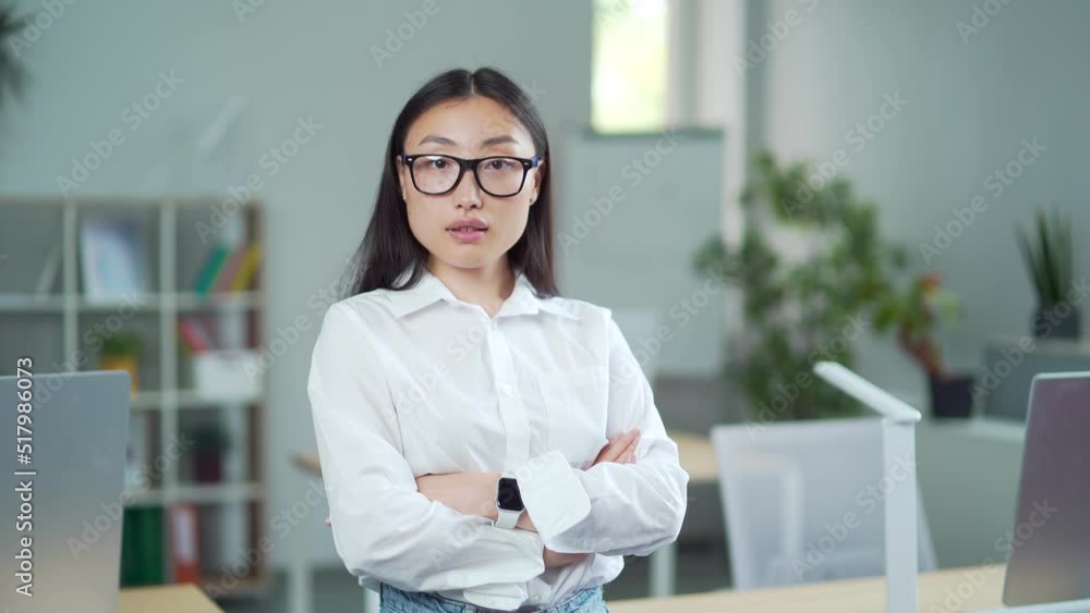 portrait of asian business lady in formal clothes and glasses looking at camera. confident proud young woman businesswoman employee student at workplace in modern office with crossed arms. Indoor portrait of asian business lady in formal clothes and glasses looking at camera. confident proud young woman businesswoman employee student at workplace in modern office with crossed arms. Indoor