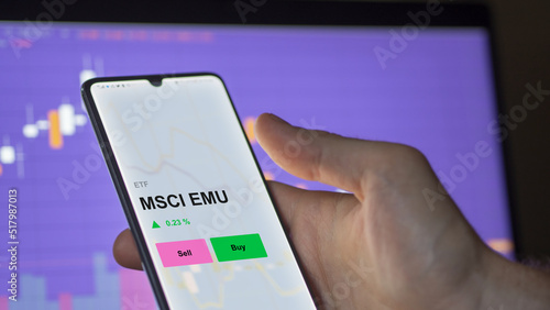 An investor's analizing the msci emu etf fund on a screen. A phone shows the prices of MSCI EMU