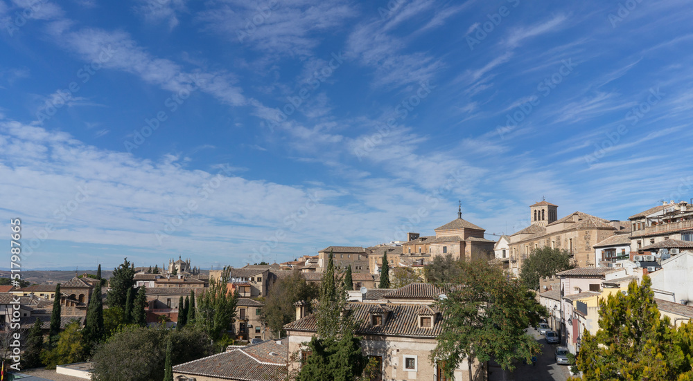 Panoramic view of the city of Toledo with some clouds in the blue sky. Spain