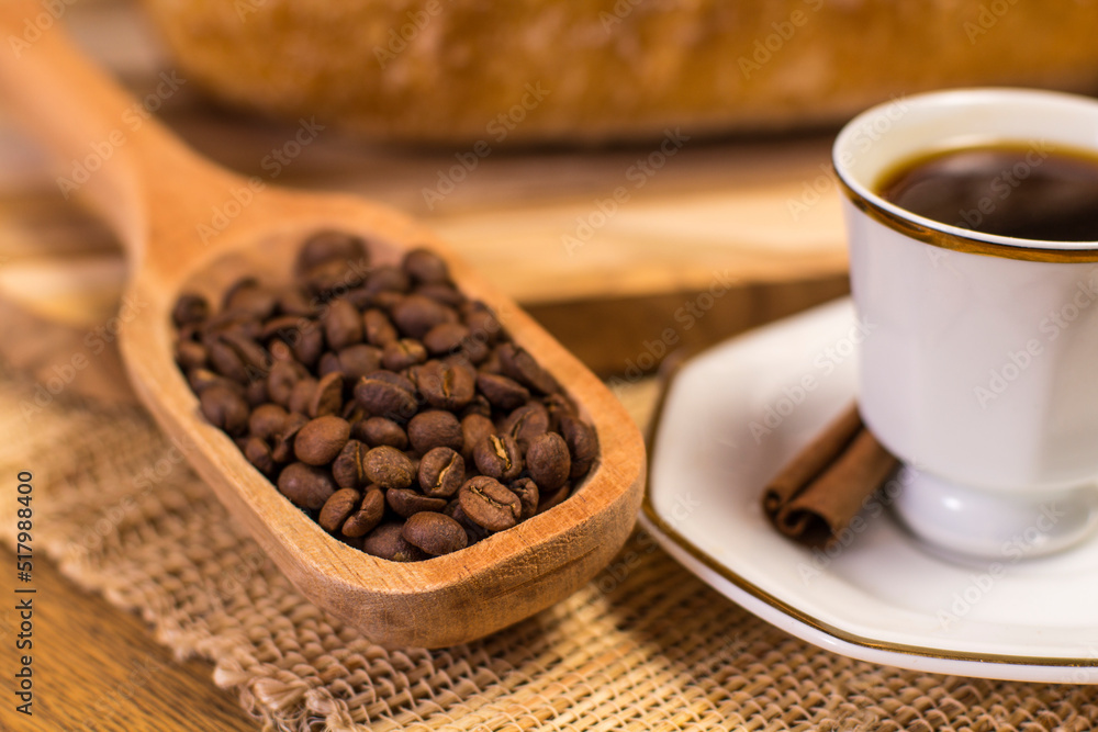 table with coffee cup and scoop of coffee beans. table with coffee cup and scoop of coffee beans.