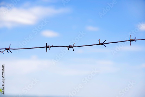 barbed wire against the blue sky.
