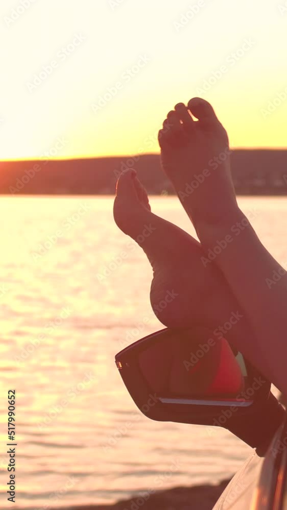 LENS FLARE, CLOSE UP Happy girl kicking her feet to the beat of the