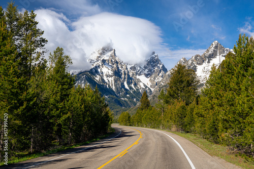 A highway curves toward mountain peaks of the Teton Range, Wyoming