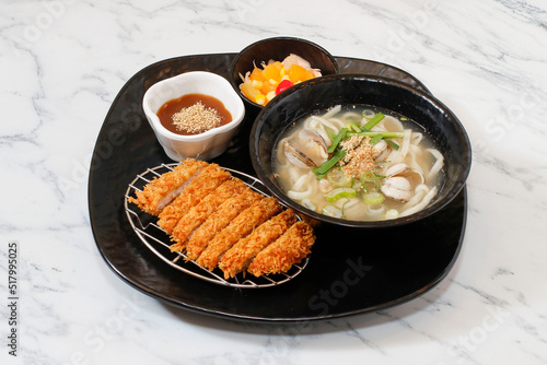 Korean clam Soup Noodle and pork cutlet set on bright background.