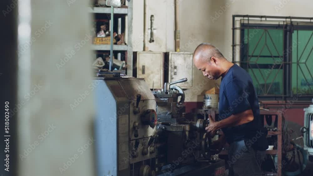 Technician asia worker using turning lathe machine for metalworking in workshop factory Technician asia worker using turning lathe machine for metalworking in workshop factory