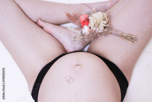 妊婦の身体とお腹の中の赤ちゃんと花束と指輪