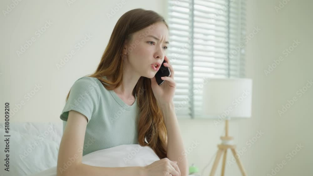 Frustrated Caucasian woman talking on mobile phone in bedroom at home. Frustrated Caucasian woman talking on mobile phone in bedroom at home.