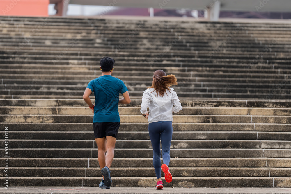 A couple of Asians are exercising and jogging up the stairs. A couple of Asians are exercising and jogging up the stairs.