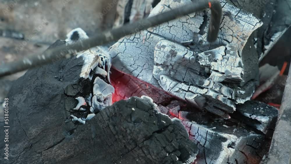 Poker breaks pieces of smoldering coal, abstract fiery background. Hot charcoal burning in grill, close-up. BBQ, cookout, picnic, camping. Poker breaks pieces of smoldering coal, abstract fiery background. Hot charcoal burning in grill, close-up. BBQ, cookout, picnic, camping.