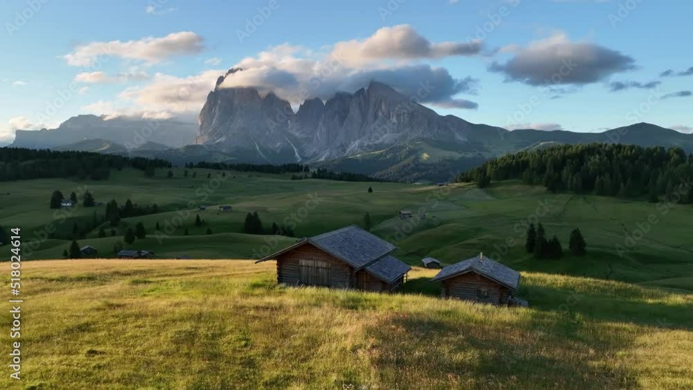 Aerial view of Seiser Alm plateau with traditional wooden mountain cottages on the meadows in Dolomites mountains in Italy . Morning drone shot of idyllic Alpe di Suisi blooming meadow in South Tyrol. Aerial view of Seiser Alm plateau with traditional wooden mountain cottages on the meadows in Dolomites mountains in Italy . Morning drone shot of idyllic Alpe di Suisi blooming meadow in South Tyrol.