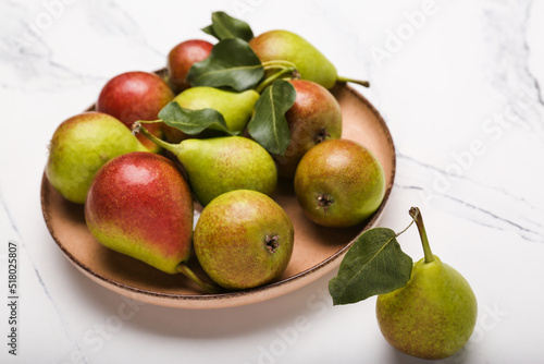 Fresh pears on light marble background