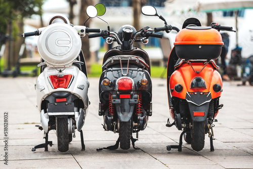 Bikes for rent. Rear view on three different scooter bike on rent parking over blurred background