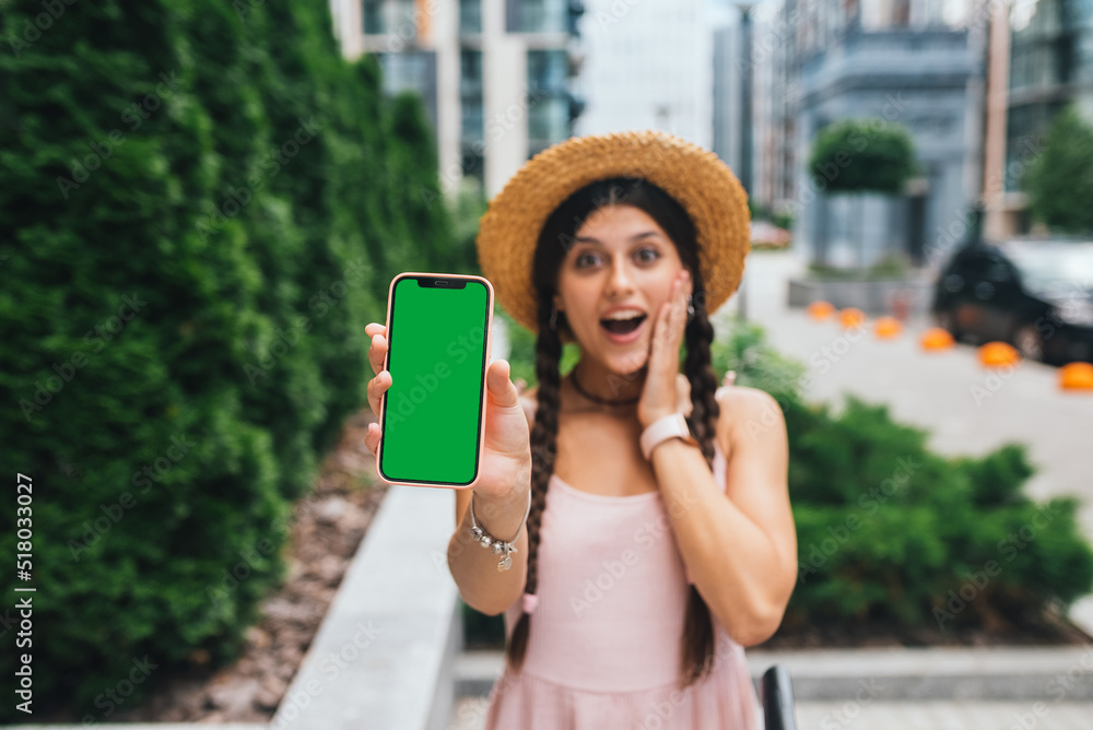 woman showing modern smartphone with green screen for replacement