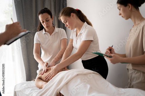 Woman teacher helping students become a masseuse, wellness massage training photo