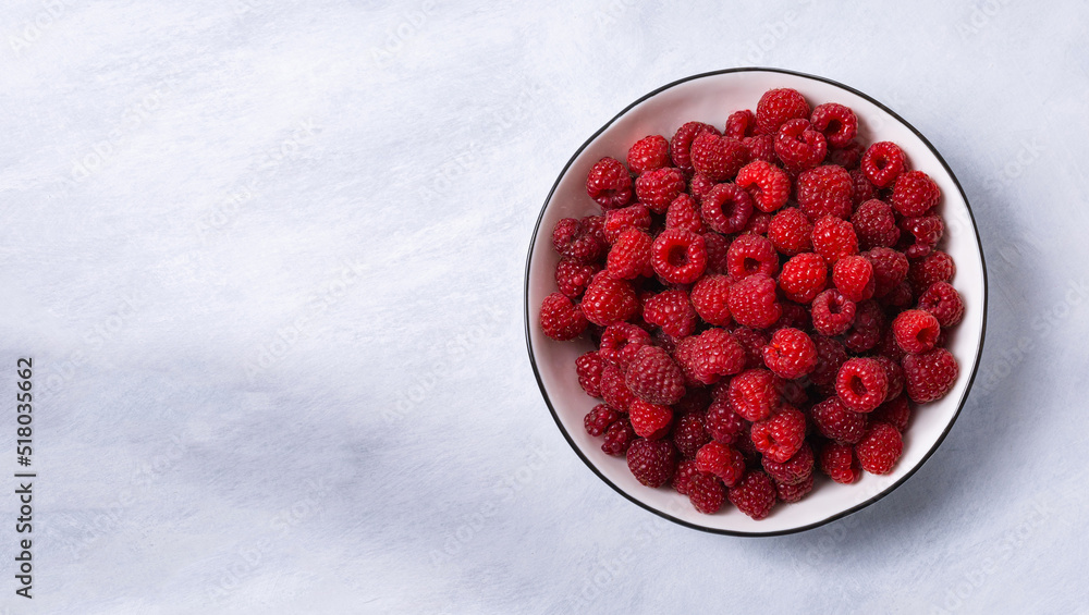 Red raspberry berry in plate on wooden table. Red raspberry berry in plate on wooden table.