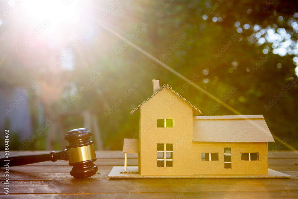 Real estate and protecting insurance concept - Invest to a family home. House model and judge gavel