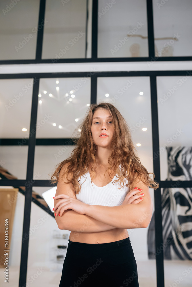 Woman in a tracksuit looks at the camera indoors. Woman in a tracksuit looks at the camera indoors.
