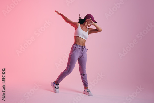 Young woman doing the dab dance move in a studio photo