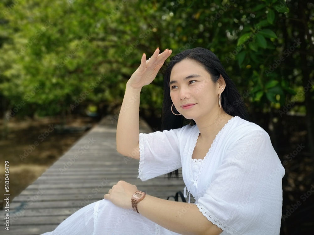 Portraits, cute girls wearing long white robes on a wooden bridge inside the mangroves, beautiful girls. Portraits, cute girls wearing long white robes on a wooden bridge inside the mangroves, beautiful girls.