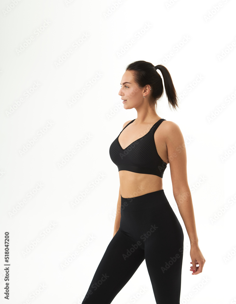Fototapeta premium Perfect slim tanned young female body in sportswear. Concept perfect body, no fat, motivation, healthy lifestyle, fitness routine. Isolated white background.