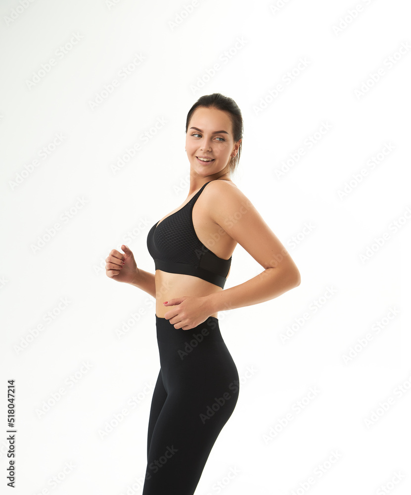Perfect slim tanned young female body in sportswear. Concept perfect body, no fat, motivation, healthy lifestyle, fitness routine. Isolated white background. Perfect slim tanned young female body in sportswear. Concept perfect body, no fat, motivation, healthy lifestyle, fitness routine. Isolated white background.