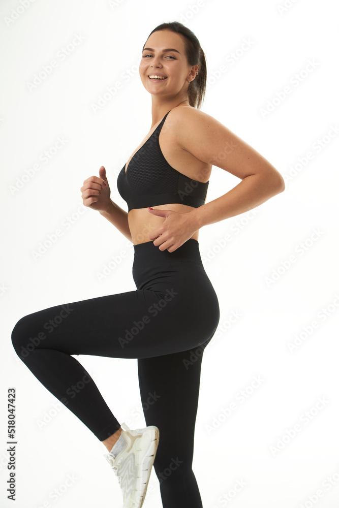 Perfect slim tanned young female body in sportswear. Concept perfect body, no fat, motivation, healthy lifestyle, fitness routine. Isolated white background. Perfect slim tanned young female body in sportswear. Concept perfect body, no fat, motivation, healthy lifestyle, fitness routine. Isolated white background.