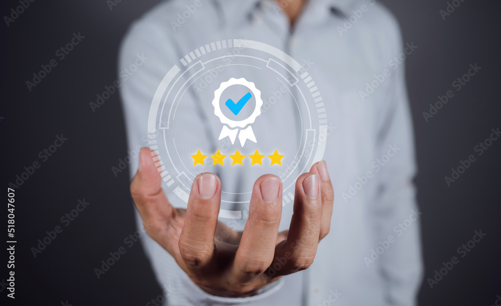 Hand shows the sign of the top service Quality assurance, Guarantee, Standards, ISO certification and standardization concept. Approved badge icon symbol medal award ribbon with 5 stars Hand shows the sign of the top service Quality assurance, Guarantee, Standards, ISO certification and standardization concept. Approved badge icon symbol medal award ribbon with 5 stars