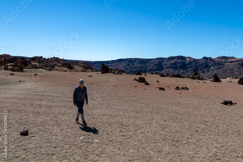 Front view of hiking woman with scenic view on moon desert landscape of Minas de San Jose Sur near volcano Pico del Teide  Mount El Teide National Park  Tenerife  Canary Islands  Spain  Europe. Awe